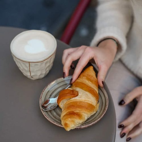 femme-prend-croissant-cafe-petit-dejeuner-honest-brussels